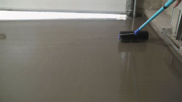 用于自流平地板的滚针。用水泥混合物把地板弄平。图片下载