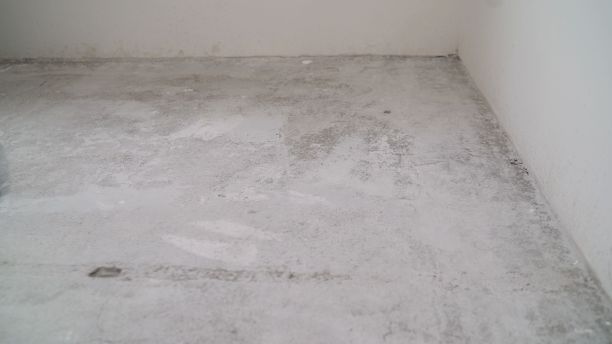 新公寓的水泥地板。混凝土地面加工前。未完成的建筑内部，白色房间的细节。空房装修前图片下载