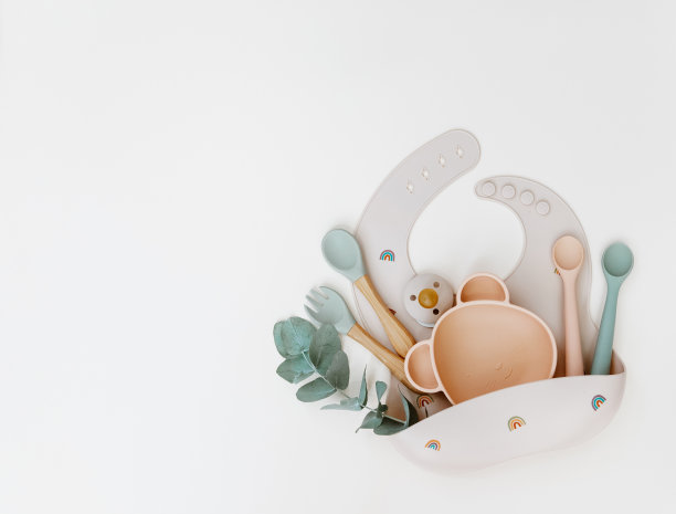 婴儿喂养配件。硅胶围兜，婴儿餐具。平铺，俯视图，拷贝空间。图片下载