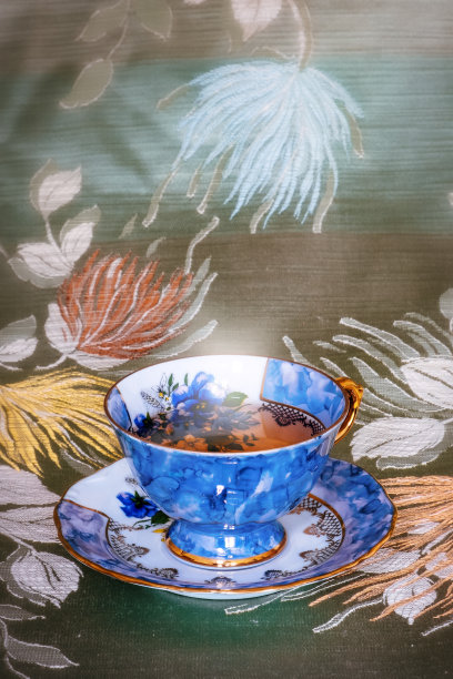 红色瓷杯的特写在繁花的背景上图片下载