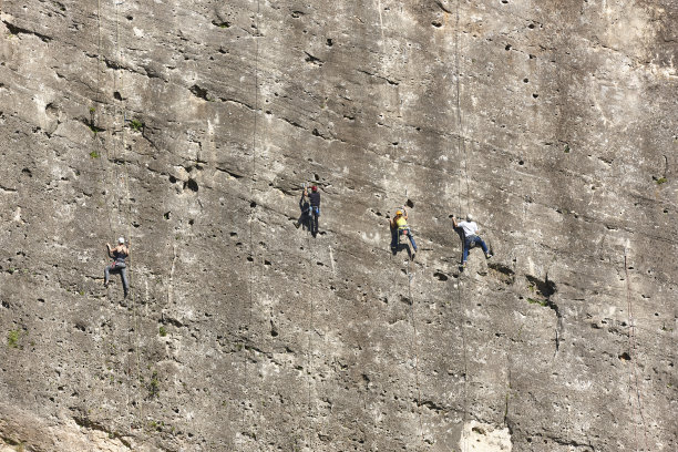 四名登山者在花岗岩墙上。极限运动。户外活动图片下载