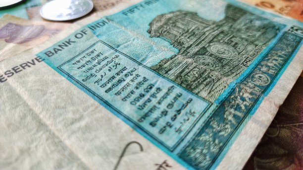 印度50卢比，印度纸币上有硬币孤立的黑色背景，储蓄和投资的概念图片下载