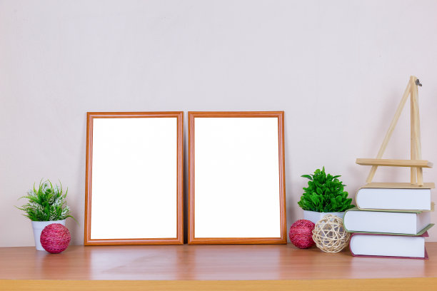 模拟棕色的相框模板，以放置图像或文本在木头桌子上的一棵小树和书。图片下载