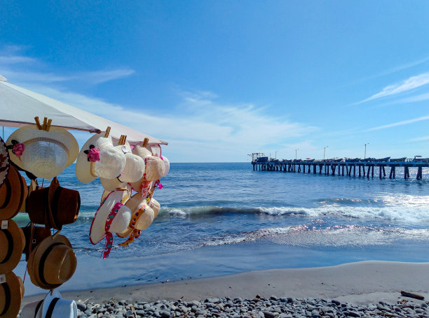 出售的沙滩帽，在背景中可以看到码头和渔港图片下载