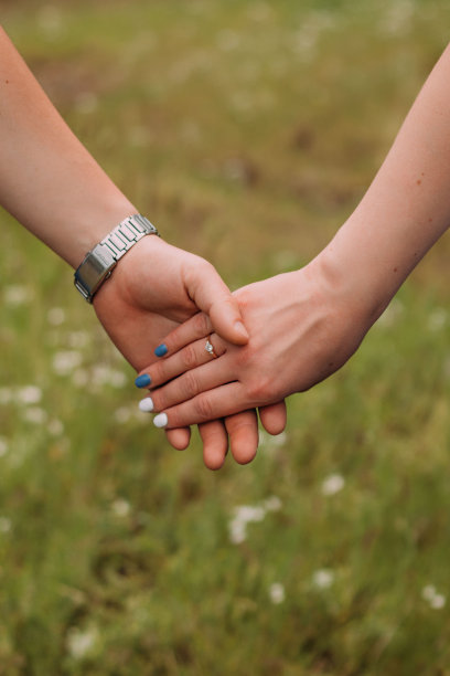 在模糊的背景上，这对相爱的夫妇手牵着手图片下载