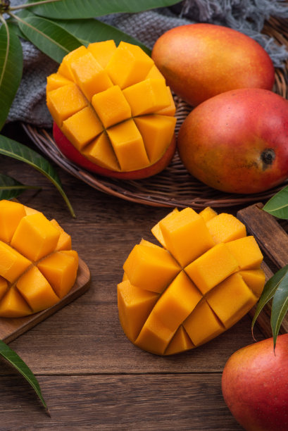 芒果。新鲜的芒果水果和树叶在深色木桌子的背景。图片下载