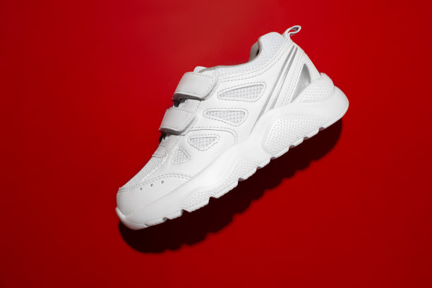 俯视图特写一件男女皆宜的跑鞋与坚硬的夏季遮阳红色背景，Velcro扣快速鞋图片下载