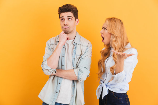 照片中的愤怒愤怒的女人尖叫着平静的无辜的人孤立，在黄色的背景图片下载