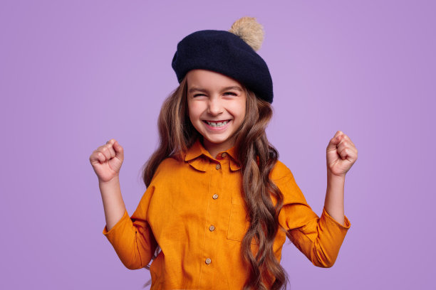 戴着帽子的快乐女孩为胜利而高兴图片下载