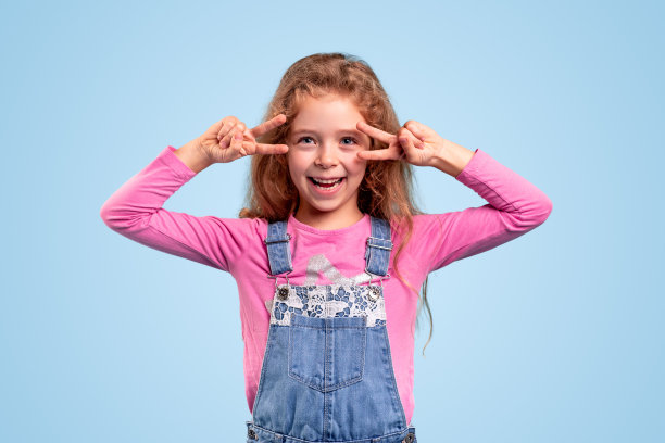 快乐的小女孩用两个手指做手势图片下载