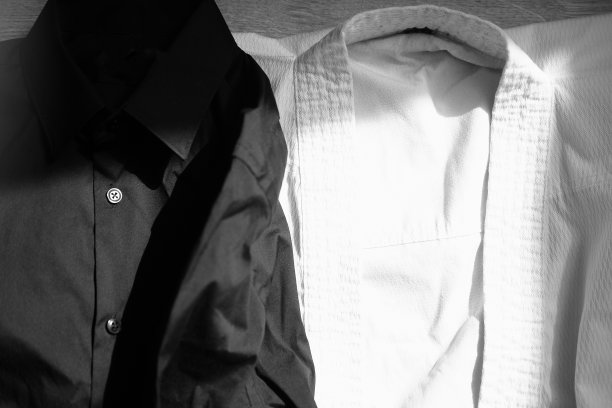 空手道训练用的白色和服。旁边是一件黑色经典衬衫图片下载