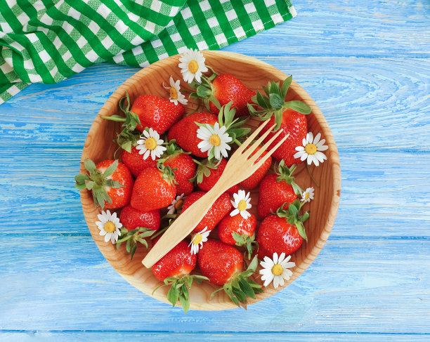 成熟的草莓，洋甘菊花在木制的背景图片下载