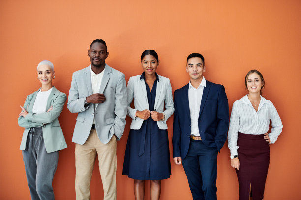 一群商人在橙色背景下站在一起的肖像图片下载