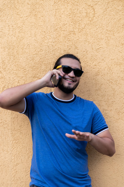 年轻的拉丁人在电话里微笑。垂直拍摄。拉丁美洲生活图片下载