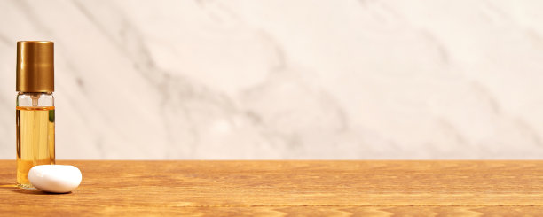 木桌上的横幅上挂着金色的香水瓶和棕色的化妆瓶。化妆品商店和美容店背景与复制空间图片下载