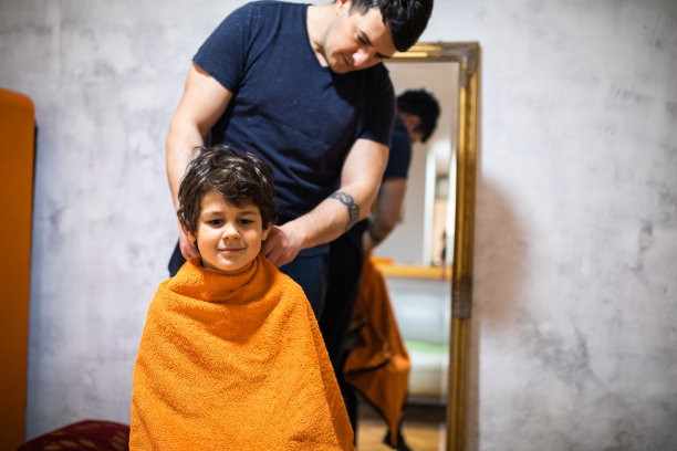 一个可爱的男孩耐心地等待他的爸爸给他在家理发图片下载