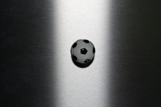 足球磁铁黑白照亮拉丝灰色金属表面。图片下载