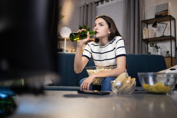 女人与食物和饮料享受足球比赛在家图片下载