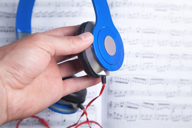 男手拿耳机上的乐谱。图片下载