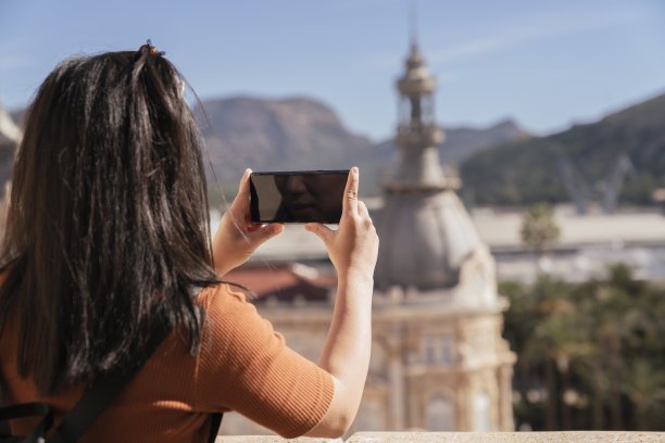 迷人的亚洲女游客旅游手用相机观光西班牙卡塔赫纳的老房子建筑建筑，带着快乐和愉悦的旅游旅行理念图片下载