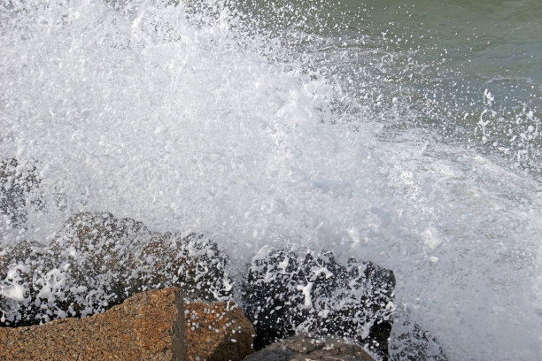 海浪撞击岩石产生白色浪花图片下载