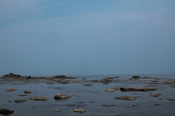 蓝色的大海上有巨大的灰色岩石和鹅卵石，海滩，度假，旅游图片下载