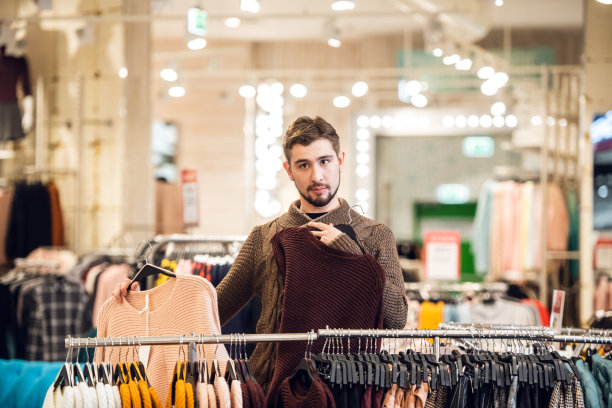 一位年轻人在百货公司为他的女朋友挑选礼物图片下载