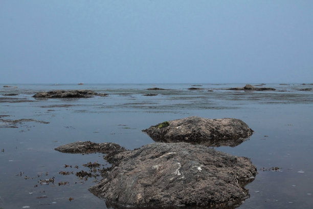 蓝色的大海上有巨大的灰色岩石和鹅卵石，海滩，度假，旅游图片下载