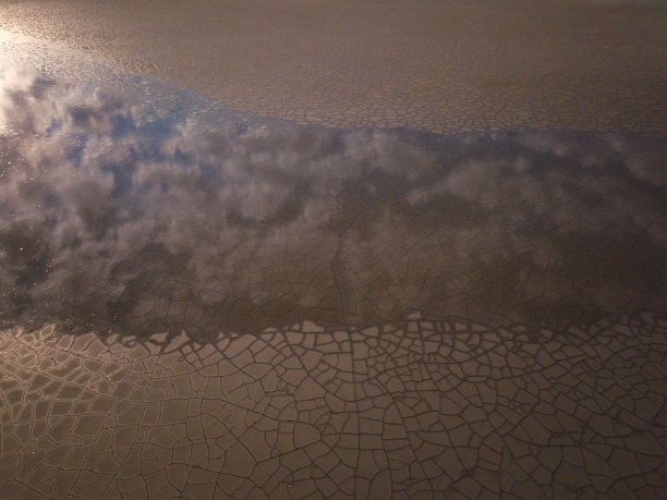 令人惊叹的陆地表面由水和破碎的地面组成，自然抽象的背景与反射图片下载