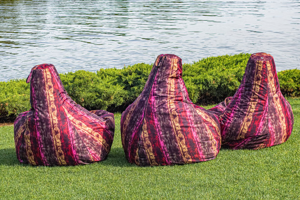 草坪上的豆袋椅，可以看到河。图片下载