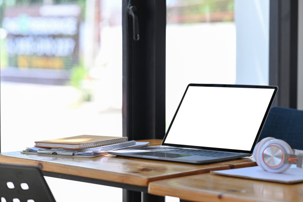 笔记本电脑，耳机，书和文件放在木桌上。图片下载