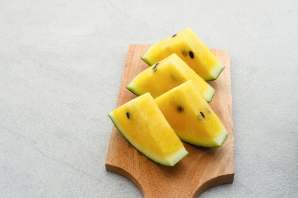 新鲜的黄色西瓜在灰色的背景，复制空间。图片下载