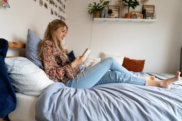 年轻女子正在床上学习图片下载