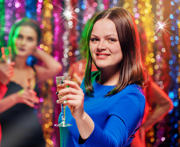 在派对上拿着香槟微笑的女人图片下载