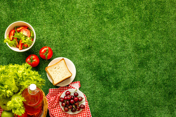 夏季野餐。篮子和食物在红布上，俯视图片下载