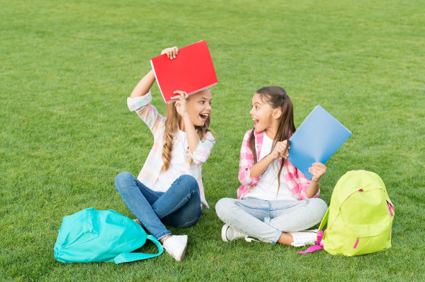 有乐趣。小朋友们在草地上休息。回到学校。文学的女孩。一起做作业。在书中找到一些有趣的东西。做笔记。在放学后度过空闲时间图片下载