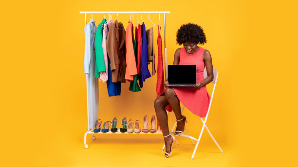 非洲女士展示笔记本电脑屏幕广告服装商店网站，工作室图片下载