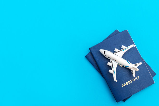 带蓝色护照的飞机玩具。前视图。空间的文本。空中旅行。图片下载