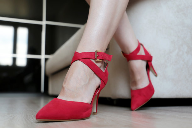 女脚穿红鞋在地板上踩高跟鞋图片下载