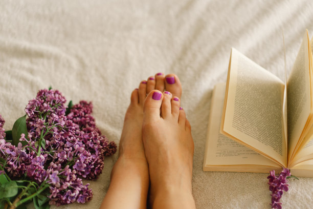 女性脚与紫色足疗，书和紫丁香。图片下载