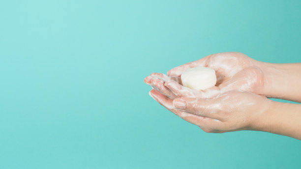 用肥皂和泡沫在薄荷绿或蒂芙尼蓝的背景上洗手手势。图片下载