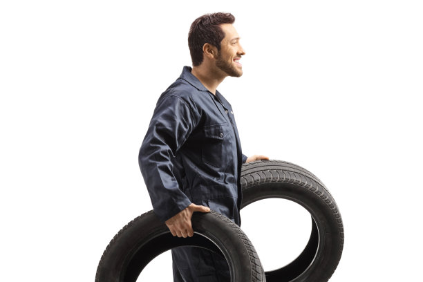 一个带着大轮胎的汽车技工图片下载