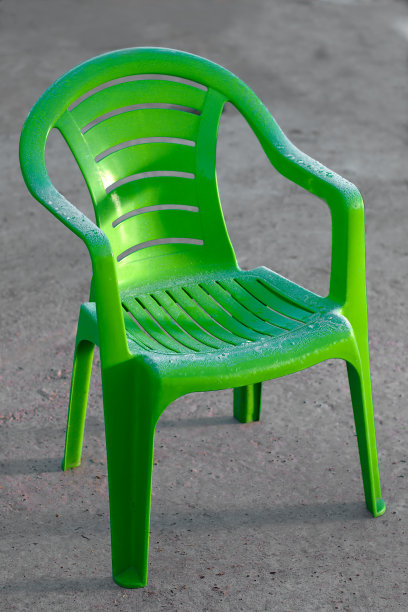 街上的水泥地板上放着一把绿色的塑料靠背椅，上面全是白霜图片下载