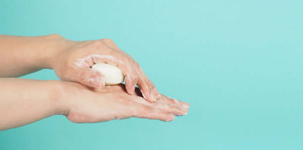 和洗涤手势与酒吧肥皂和泡沫薄荷绿或蒂凡尼蓝色的背景。图片下载