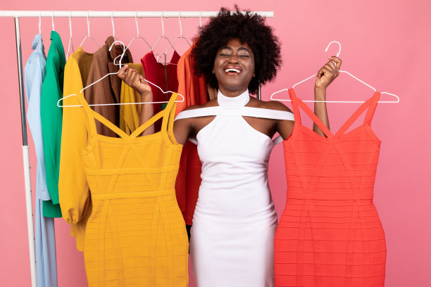 不开心的购物狂女士在两件裙子中选择粉色背景图片下载