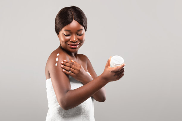 身体保健的概念。年轻的非洲裔美国女性在皮肤上使用保湿乳液图片下载