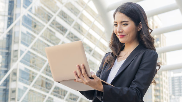 商务女孩与电脑笔记本和城市。美丽的亚洲女孩用笔记本庆祝，成功快乐的姿势。电子商务，大学教育，互联网技术，或创业小型企业的概念。图片下载