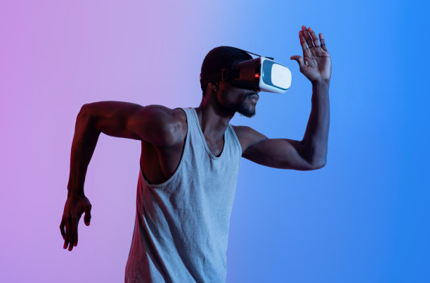 侧面的年轻的非裔美国人在VR头盔运行在霓虹灯。未来技术的概念图片下载