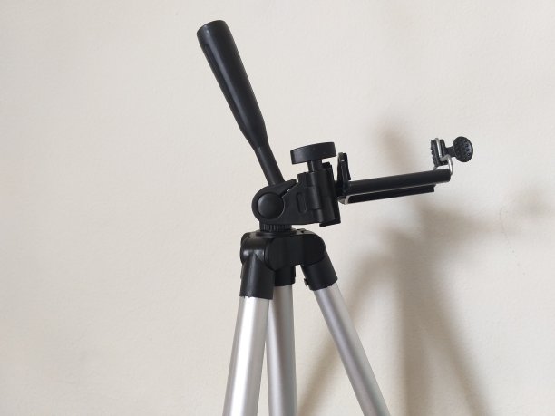 小三脚架照片，以白墙为背景图片下载