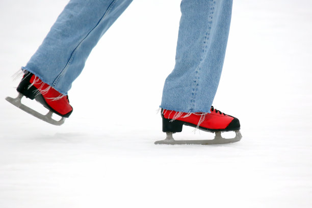 穿着红色溜冰鞋的脚在溜冰场上。爱好和休闲。冬季运动图片下载